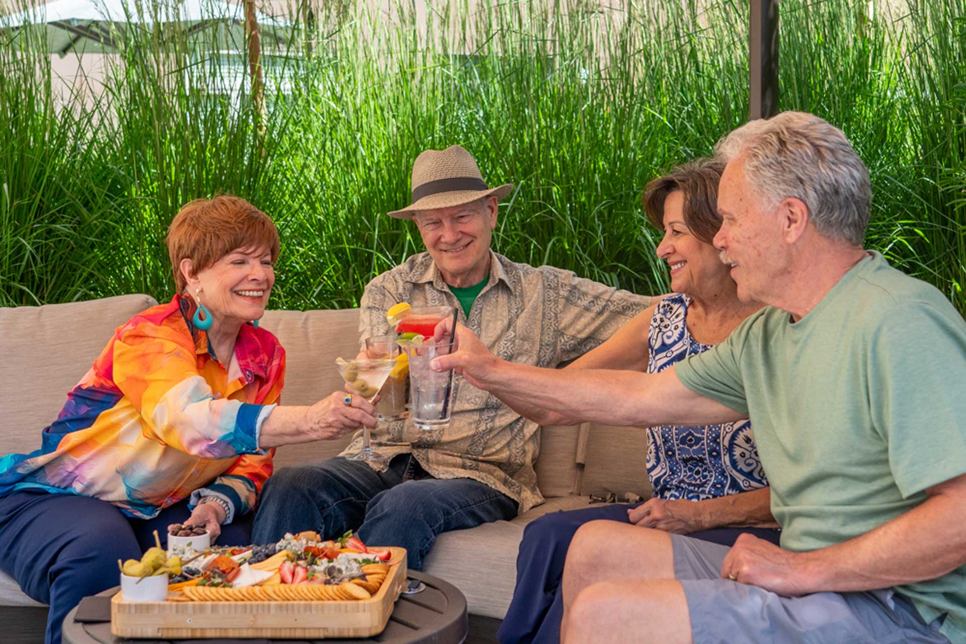 A group of retirees are enjoying a fresh beverage and snacks in an outdoor seating area.