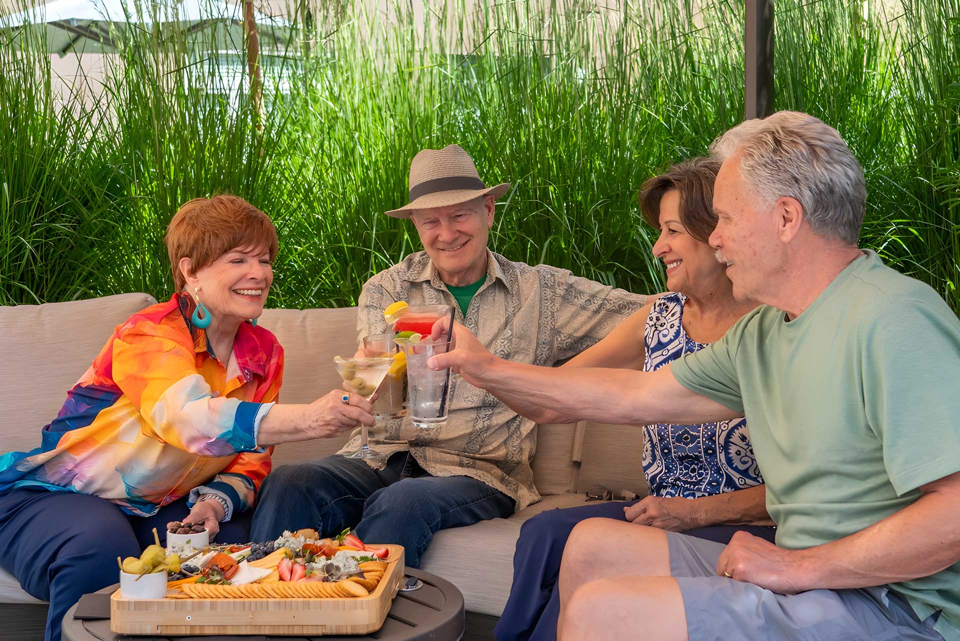 A group of retirees are enjoying a fresh beverage and snacks in an outdoor seating area.