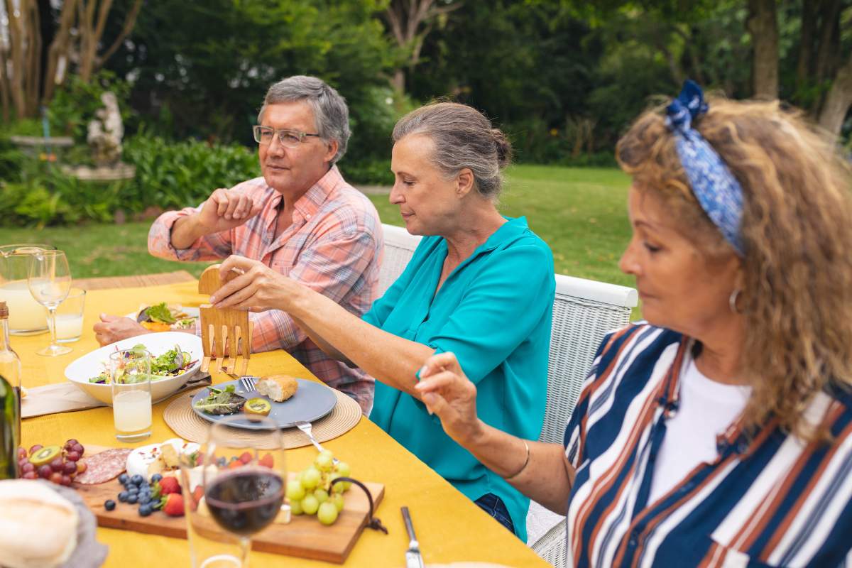 A group of senior friends enjoying lunch outdoors
